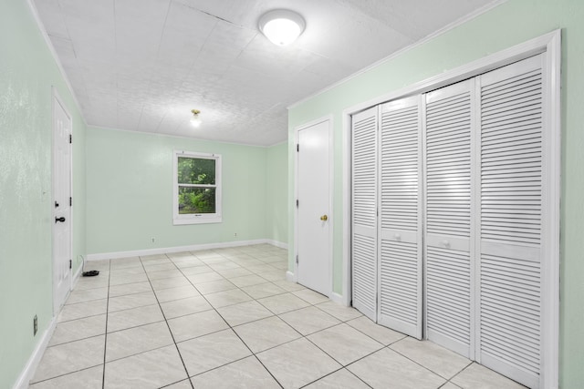 2116 N Campbell Ave, Springfield, MO 65803 - unfurnished bedroom with a closet, light tile patterned flooring, and baseboards