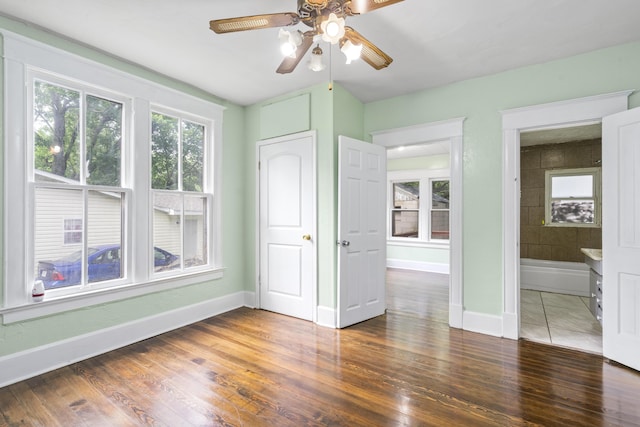 2116 N Campbell Ave, Springfield, MO 65803 - unfurnished bedroom featuring baseboards, wood finished floors, ensuite bath, and ceiling fan