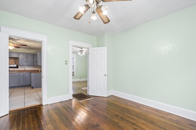 2116 N Campbell Ave, Springfield, MO 65803 - unfurnished bedroom featuring wood-type flooring, baseboards, connected bathroom, and a sink
