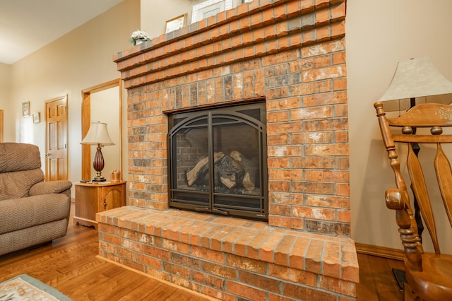 8326 Shinnecock Dr, Nixa, MO 65714 - living area featuring wood finished floors, baseboards, and a brick fireplace