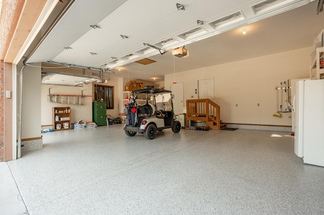8326 Shinnecock Dr, Nixa, MO 65714 - garage with a garage door opener, freestanding refrigerator, and baseboards