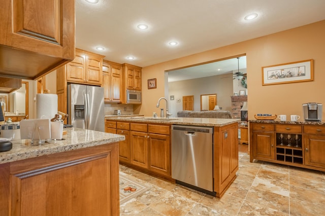 8326 Shinnecock Dr, Nixa, MO 65714 - kitchen featuring stainless steel appliances, a sink, light stone counters, ceiling fan, and recessed lighting