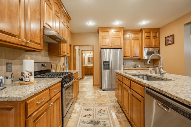 8326 Shinnecock Dr, Nixa, MO 65714 - kitchen with appliances with stainless steel finishes, under cabinet range hood, a sink, light stone countertops, and decorative backsplash