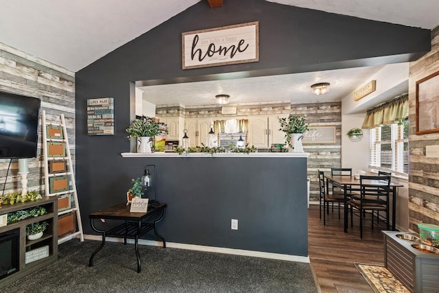 1127 E Livingston Ct, Springfield, MO 65803 - kitchen featuring lofted ceiling, a peninsula, an accent wall, baseboards, and wood finished floors