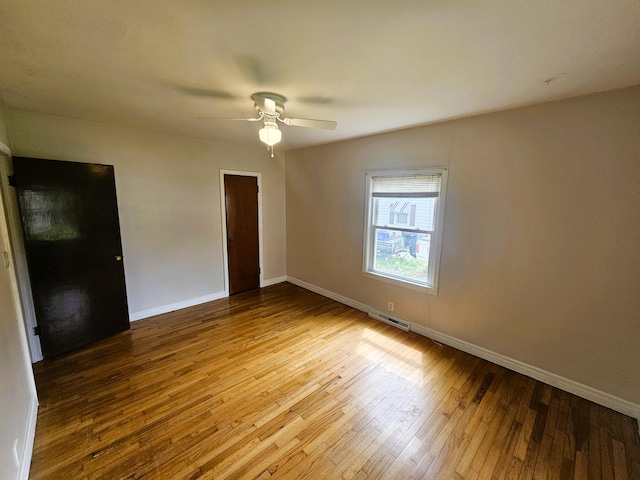 107 W Poplar St, El Dorado Springs, MO 64744 - spare room featuring wood-type flooring, baseboards, and ceiling fan