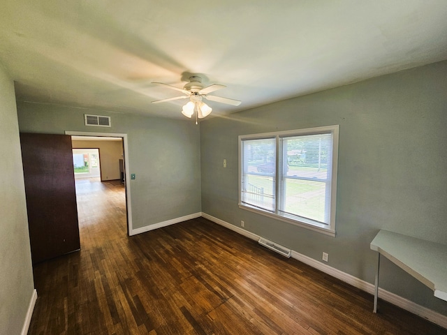 107 W Poplar St, El Dorado Springs, MO 64744 - spare room with dark wood-style flooring, ceiling fan, and baseboards
