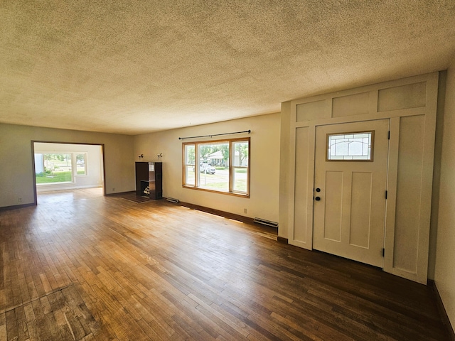 107 W Poplar St, El Dorado Springs, MO 64744 - entrance foyer featuring hardwood / wood-style floors, a textured ceiling, baseboards, and baseboard heating