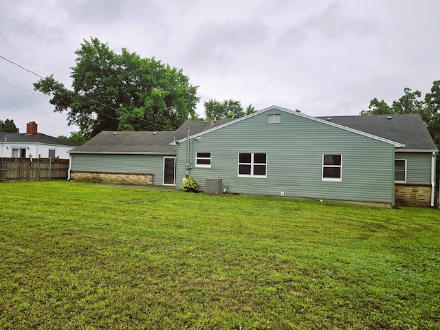 107 W Poplar St, El Dorado Springs, MO 64744 - rear view of property featuring central AC and a shingled roof