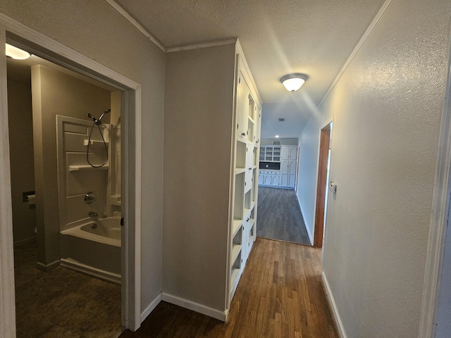 107 W Poplar St, El Dorado Springs, MO 64744 - hall featuring dark wood-type flooring, ornamental molding, baseboards, a textured ceiling, and a textured wall