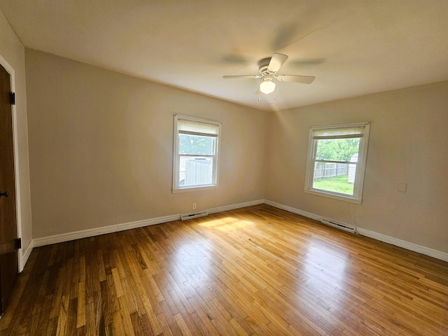 107 W Poplar St, El Dorado Springs, MO 64744 - empty room featuring plenty of natural light, wood-type flooring, ceiling fan, and baseboards