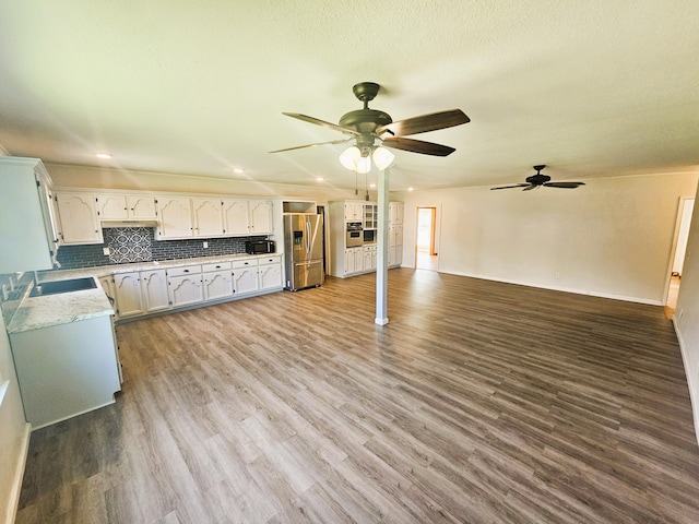 107 W Poplar St, El Dorado Springs, MO 64744 - unfurnished living room with a ceiling fan, wood finished floors, recessed lighting, a sink, and baseboards