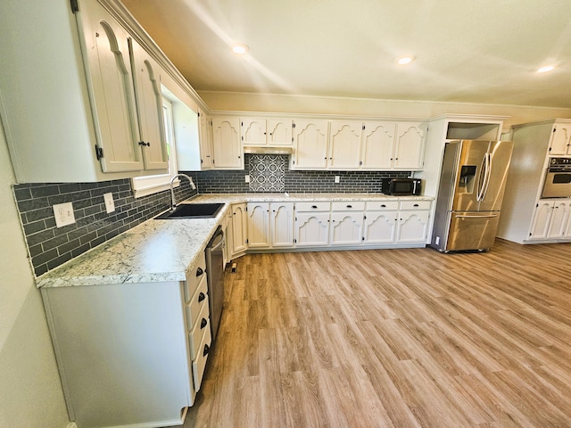 107 W Poplar St, El Dorado Springs, MO 64744 - kitchen with appliances with stainless steel finishes, a sink, decorative backsplash, light wood-style floors, and recessed lighting
