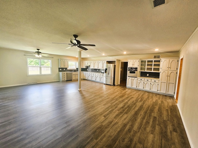 107 W Poplar St, El Dorado Springs, MO 64744 - unfurnished living room with dark wood-style flooring, a textured ceiling, baseboards, ceiling fan, and recessed lighting