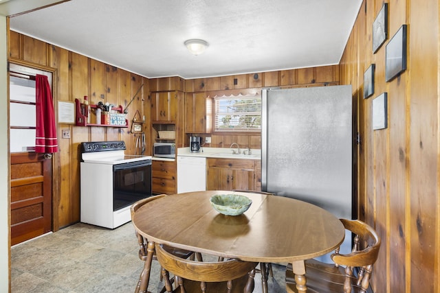 638 Double Day, Branson West, MO 65737 - kitchen featuring stainless steel appliances, a sink, wood walls, brown cabinetry, and light countertops