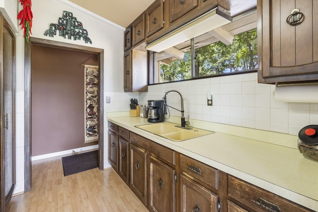 638 Double Day, Branson West, MO 65737 - kitchen with a sink, light countertops, decorative backsplash, light wood-style flooring, and dark brown cabinets