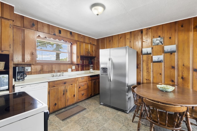 638 Double Day, Branson West, MO 65737 - kitchen with stainless steel fridge, a sink, brown cabinetry, wooden walls, and light countertops