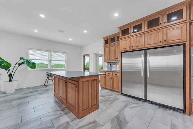 108 Island Green Dr, Republic, MO 65738 - kitchen featuring freestanding refrigerator, brown cabinets, a kitchen island, recessed lighting, and dark countertops