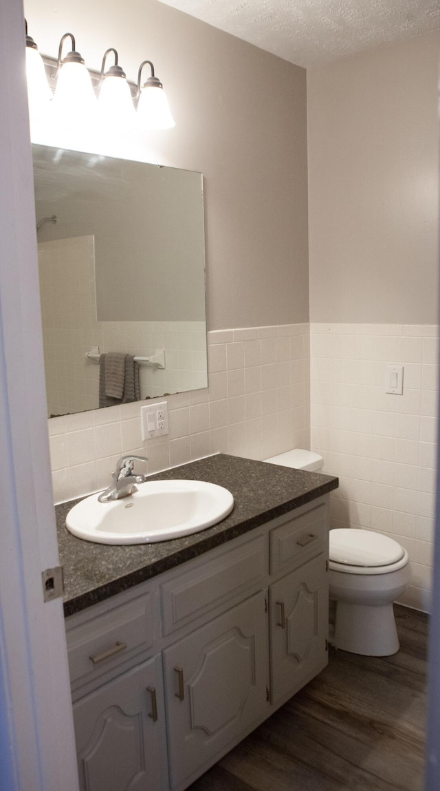 18627 Farm Rd Unit 1075, Exeter, MO 65647 - bathroom with tile walls, vanity, toilet, wood finished floors, and a wainscoted wall