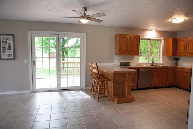 18627 Farm Rd Unit 1075, Exeter, MO 65647 - kitchen with stainless steel dishwasher, plenty of natural light, a peninsula, a ceiling fan, and a textured ceiling