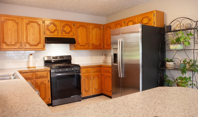 18627 Farm Rd Unit 1075, Exeter, MO 65647 - kitchen featuring stainless steel appliances, under cabinet range hood, light countertops, brown cabinets, and a textured ceiling