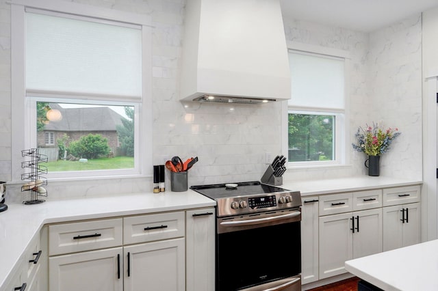 498 Mockingbird, Rogersville, MO 65742 - kitchen with stainless steel electric range, premium range hood, backsplash, white cabinets, and light countertops
