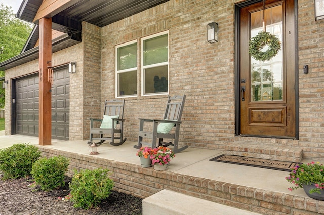 498 Mockingbird, Rogersville, MO 65742 - entrance to property featuring concrete driveway, a garage, a porch, and brick siding