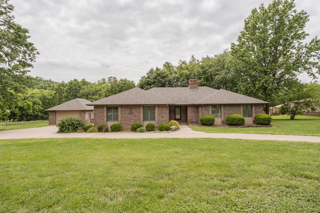175 Covered Bridge Dr, Ozark, MO 65721 - ranch-style house featuring a front yard, brick siding, a chimney, and a shingled roof