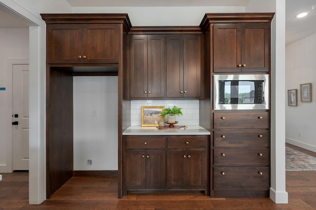 1756 N Marlowe Ave, Springfield, MO 65802 - kitchen with stainless steel microwave, baseboards, dark brown cabinets, tasteful backsplash, and dark wood finished floors