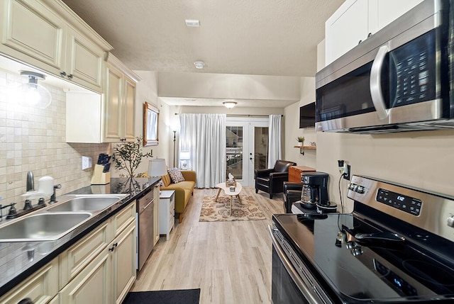 180 Grace Chapel Rd Unit 321, Blue Eye, MO 65611 - kitchen with stainless steel appliances, a sink, dark countertops, light wood finished floors, and decorative backsplash
