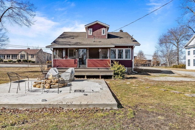310 S Main St, Licking, MO 65542 - rear view of house featuring a sunroom, an outdoor fire pit, a shingled roof, a lawn, and a patio