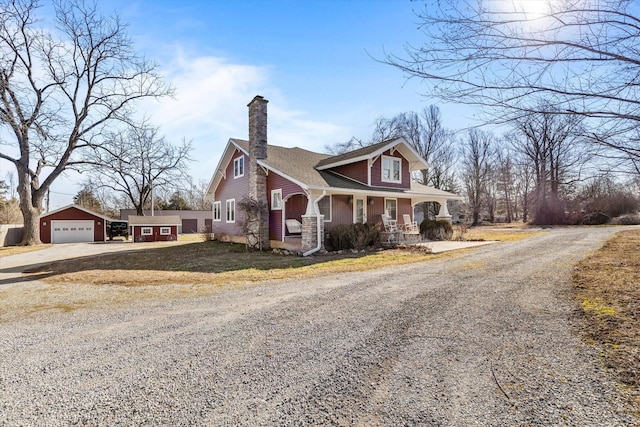 310 S Main St, Licking, MO 65542 - view of front facade featuring gravel driveway, covered porch, an outbuilding, a chimney, and roof with shingles