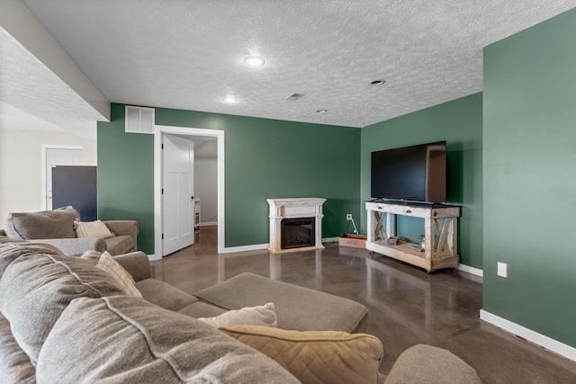 living room featuring baseboards, finished concrete floors, a textured ceiling, a fireplace, and recessed lighting