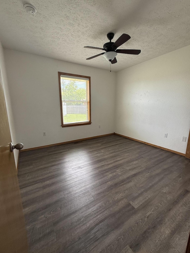 6004 N 6th Ave, Ozark, MO 65721 - spare room featuring baseboards, dark wood-style flooring, ceiling fan, and a textured ceiling