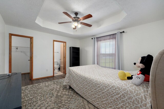 6004 N 6th Ave, Ozark, MO 65721 - bedroom featuring wood finished floors, a tray ceiling, a spacious closet, baseboards, and a textured ceiling
