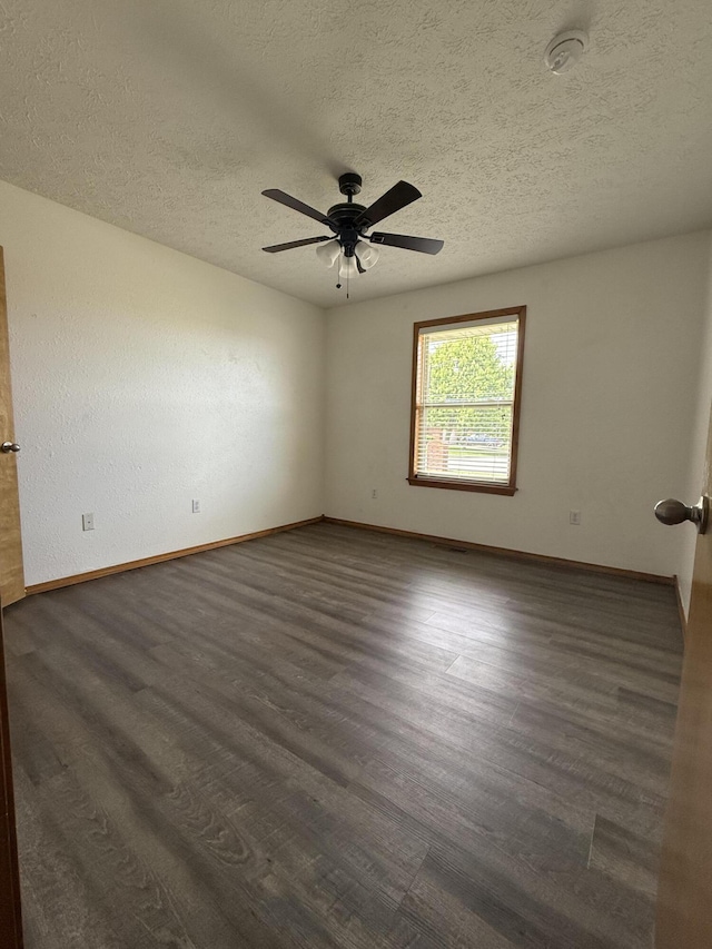 6004 N 6th Ave, Ozark, MO 65721 - unfurnished room featuring a textured ceiling, dark wood-type flooring, baseboards, a ceiling fan, and a smoke detector