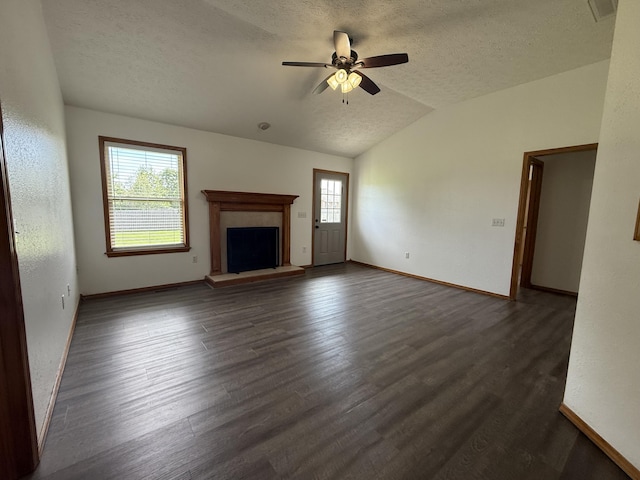6004 N 6th Ave, Ozark, MO 65721 - unfurnished living room featuring a textured ceiling, baseboards, vaulted ceiling, a fireplace with raised hearth, and a ceiling fan