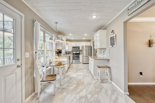 287 Appletree Dr, Ozark, MO 65721 - kitchen with stainless steel appliances, white cabinetry, a kitchen bar, light stone countertops, and decorative backsplash