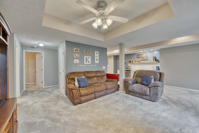 287 Appletree Dr, Ozark, MO 65721 - carpeted living room featuring a textured ceiling, a ceiling fan, baseboards, and a raised ceiling