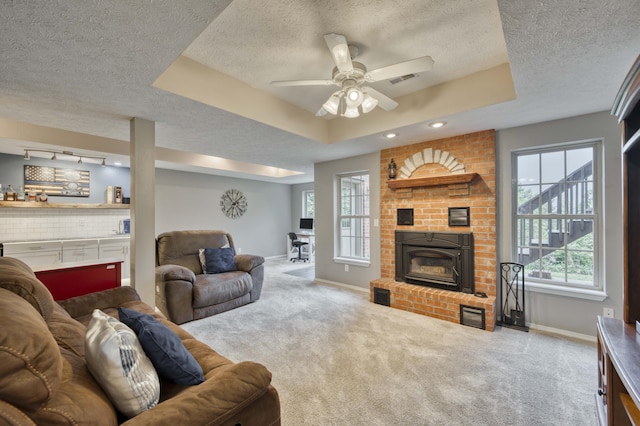 287 Appletree Dr, Ozark, MO 65721 - living room featuring a textured ceiling, baseboards, carpet, a ceiling fan, and a tray ceiling