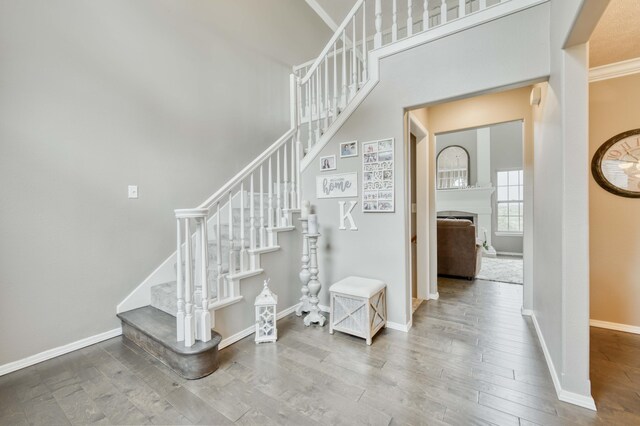 287 Appletree Dr, Ozark, MO 65721 - staircase with wood finished floors, baseboards, crown molding, a fireplace, and a high ceiling
