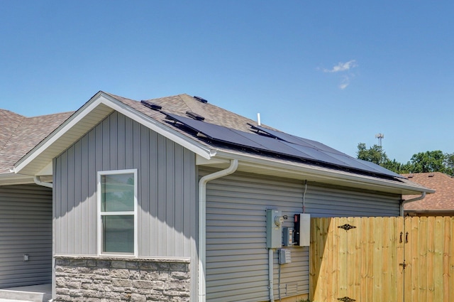 511 Mark St, Billings, MO 65610 - view of home's exterior with a shingled roof, roof mounted solar panels, and stone siding