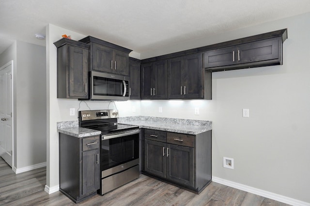511 Mark St, Billings, MO 65610 - kitchen featuring appliances with stainless steel finishes, light wood-style floors, light countertops, and dark brown cabinetry