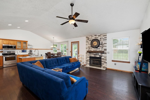 5204 W Turnberry Ct, Ozark, MO 65721 - living room with lofted ceiling, a ceiling fan, dark wood-style flooring, a chandelier, and a stone fireplace