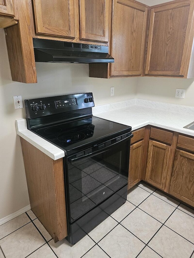 3807 S Leawood Ave, Springfield, MO 65807 - kitchen featuring black electric range, under cabinet range hood, light countertops, and brown cabinets