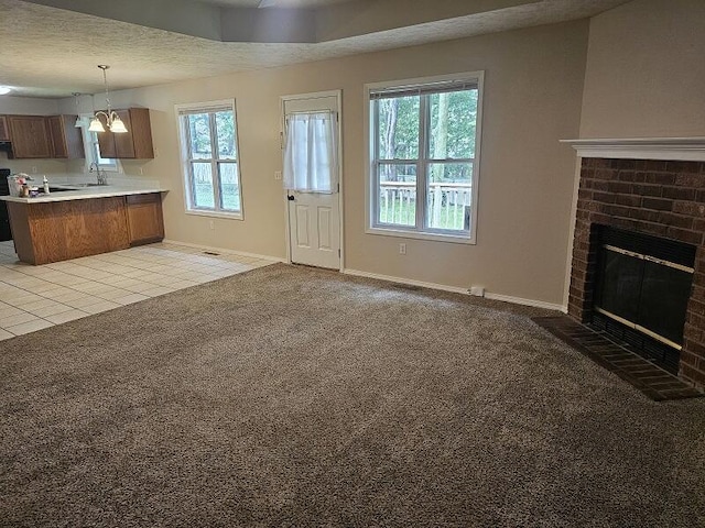 3807 S Leawood Ave, Springfield, MO 65807 - unfurnished living room featuring a fireplace, light carpet, baseboards, a sink, and light tile patterned flooring