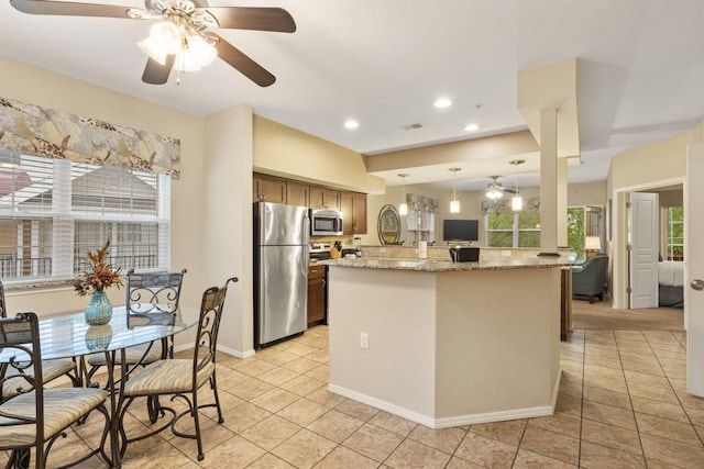 2800 Green Mountain Dr Unit 230, Branson, MO 65616 - kitchen featuring stainless steel appliances, a ceiling fan, light tile patterned flooring, decorative light fixtures, and light stone counters