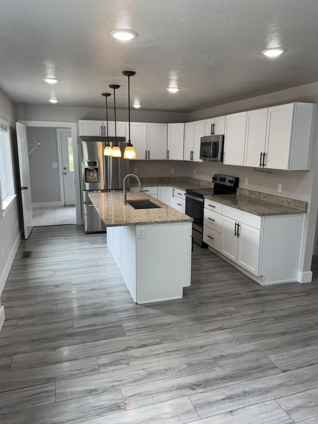 108 Jasper St, Aurora, MO 65605 - kitchen with stainless steel appliances, a sink, baseboards, white cabinetry, and light stone countertops