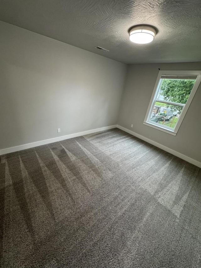 108 Jasper St, Aurora, MO 65605 - spare room with a textured ceiling, baseboards, and dark colored carpet