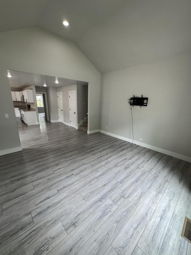 108 Jasper St, Aurora, MO 65605 - unfurnished living room featuring vaulted ceiling, dark wood-style floors, baseboards, and recessed lighting
