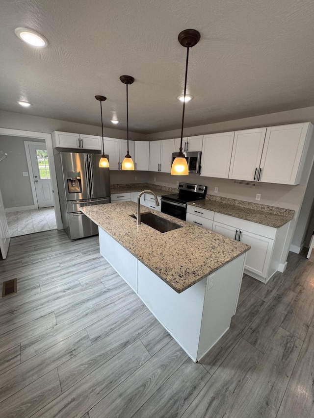 108 Jasper St, Aurora, MO 65605 - kitchen with appliances with stainless steel finishes, a sink, white cabinetry, light stone countertops, and recessed lighting